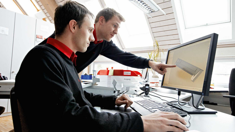 Dwóch mężczyzn omawia model 3D na komputerze